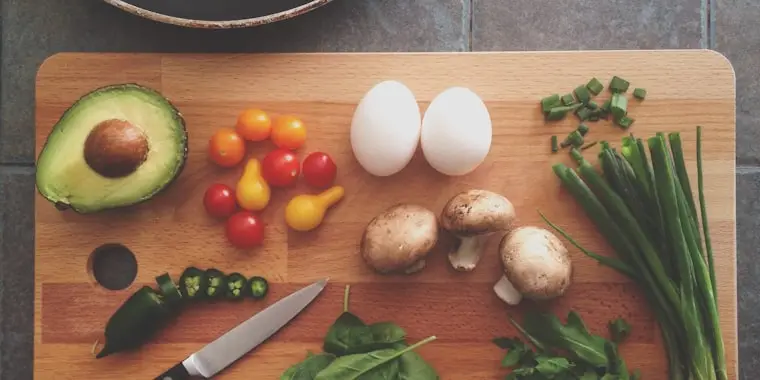 Verduras y huevos sobre una tabla de cortar